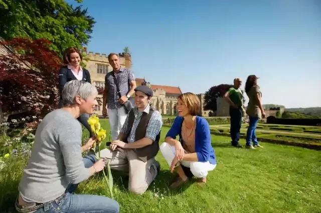 Eine Reisegruppe genießt die Natur und bewundert Blumen in einem schönen Garten.