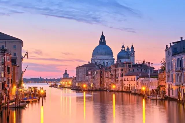 Abendstimmung mit beleuchteten Gebäuden am Grand Canal in Venedig.