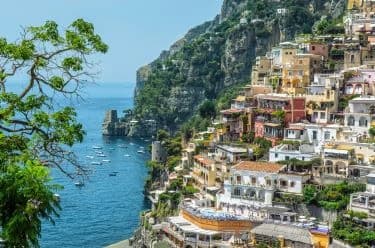 Berghang-Dorf Positano in Italien mit zahlreichen Terrassen und Gärten am Meer.