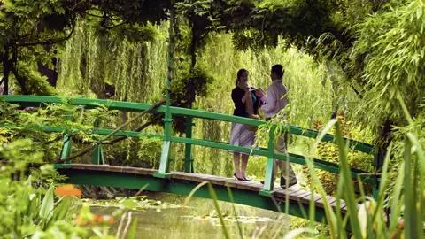 Auf unserer Rundreise mit Studiosus sehen wir ein Paar, dass auf der Japanischen Brücke in Monets Garten in der Normandie steht