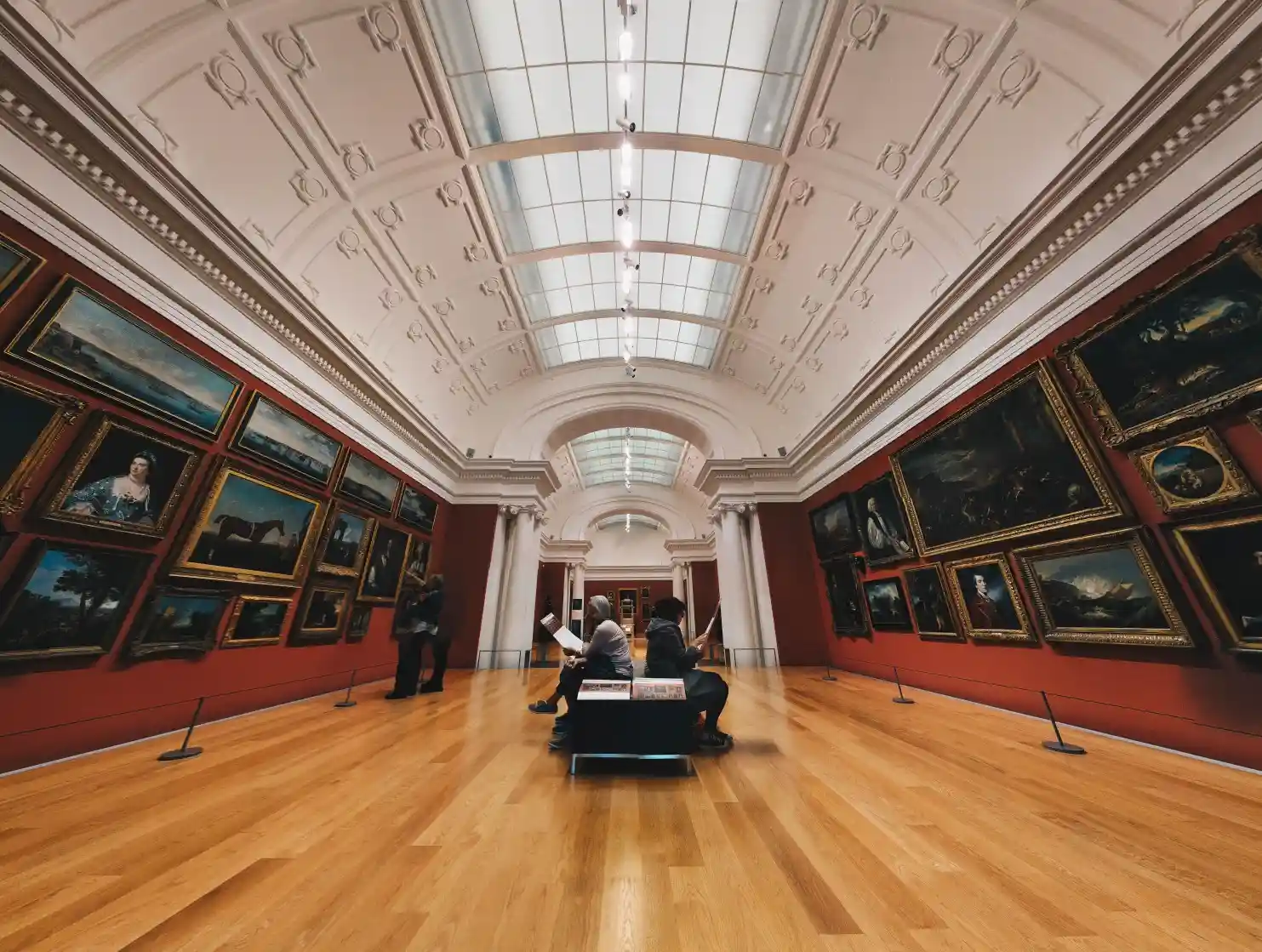 Innenansicht einer Kunstgalerie mit Gemälden an den Wänden.