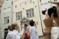 Touristen besichtigen und fotografieren die Drei Brüder, ein historisches Gebäudeensemble in Riga.