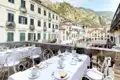 Aussicht von dem Balkonrestaurant unseres Hotels in Kotor auf einen belebten Marktplatz, umgeben von historischen Gebäuden und Bergen