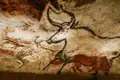 Höhlenmalereien in Lascaux, die einen großen gehörnten Ochsen, Pferde und Hirsche zeigen.