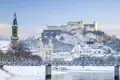 Auf unserer Grupenreise genießen wir den weiten Blick auf die Salzach mit der versschneiten Festung Hohensalzburg im Hintergrund