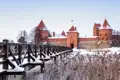 Die rote Backsteinburg Trakai in einer verschneiten Winterlandschaft, ein im Reiseverlauf inkludierter Programmpunkt  dieser Reise.