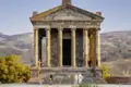 Der römisch-hellenistische Tempel von Garni, eine Sehenswürdigkeit, die auf unserer Armenienreise besichtigt wird, steht vor einer hügeligen Landschaft.