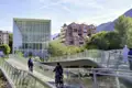 Zwei Radfahrer auf einer geschwungenen Brücke über die Talfer in Bozen, im Hintergrund das Museum Museion, ein toller Stopp auf unserer Rundreise mit Studiosus.