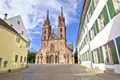 Das gotische Basler Münster aus rotem Sandstein auf dem gepflasterten Münsterplatz während einer Studienreise in der Schweiz.