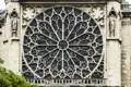 Detailansicht des gotischen Rosettenfensters mit filigranem Maßwerk an der Steinfassade der Kathedrale Notre-Dame in Paris, welches wir auf unserer Rundreise nach Paris entdecken
