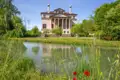 Auf unserer Gruppenreise mit Studiosus besuchen wir die Palladios Villa Foscari am Brenta-Kanal im Veneto, die sich an einem sonnigen Tag im Wasser vor einer grünen Uferlandschaft spiegelt.