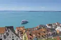 Ausblick einer Eventreise: Ein weißes Ausflugsschiff fährt auf dem Bodensee vor der malerischen Altstadt von Meersburg, ein Highlight unserer Studiosus Rundreise