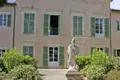 Außenansicht von Napoleons Villa dei Mulini in Portoferraio auf Elba mit einer Statue im Vordergrund und grünen Fensterläden, ein Highlight unserer Rundreise durch Italien.