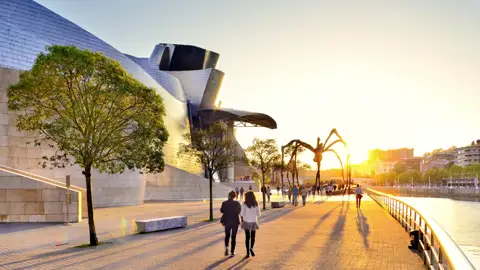 Auf unserer Städtereise CityLights Bilbao erleben Sie in kleiner Gruppe und mit Studiosus-Reiseleitung die Höhepunkte der Stadt, beispielsweise das Guggenheim-Museum mit der Skulptur "Maman" bei Sonnenuntergang.