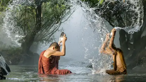 Der Buddhiusmus begegnet uns bei der Rundreise in Thailand immer wieder. Hier waschen sich buddhistische Mönche in einem Fluss.