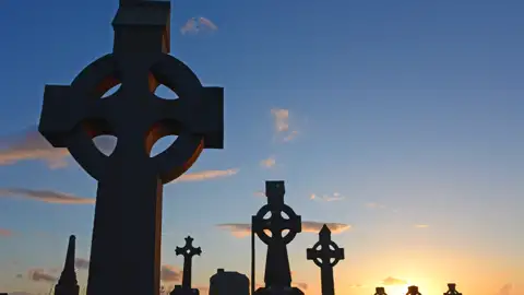 Auf unsrer Rundreise durch Irland und Nordirland sehen wir zahlreiche der typischen keltischen Hochkreuze. Das wohl schönste steht in Monasterboice, aber auch auf vielen Friedhöfen, wie hier im Abendlicht sind sie zahlreich zu finden.