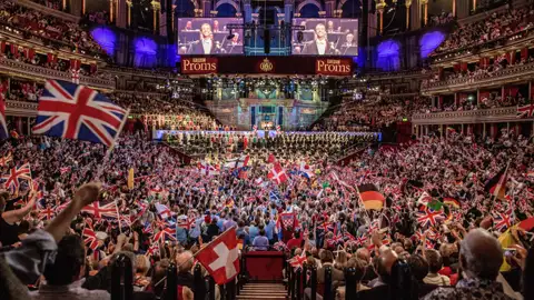 Begeistertes Publikum schwenkt Flaggen bei der Last Night of the Proms in der prachtvollen Royal Albert Hall in London, ein Highlight auf unserer Kultimer Eventreise.