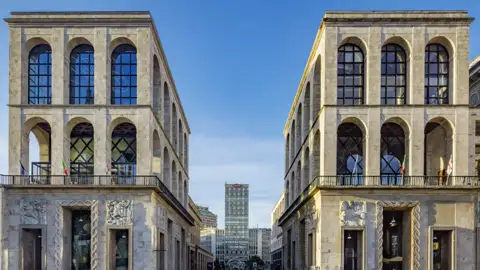 Auf unserer Eventreise mit Studiosus nach Italien bewundern wir symmetrische Fassaden des Palazzo dell’Arengario in Mailand mit großen Rundbogenfenstern und Blick auf die Torre Velasca.