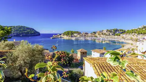Auf Ihrer Gruppenreise habe Sie einen malerischen Blick über mediterrane Ziegeldächer, auf die sonnige Bucht und den Hafen von Port de Sóller auf Mallorca.