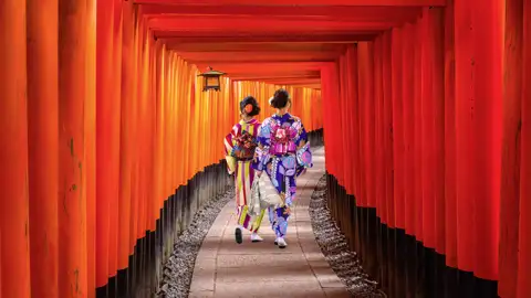 Auf diieser Studienreise durch Japan können Sie wie diese Geishas durch die roten Tori des Fushimi-Inari-Schreins in der alten Kaiserstadt Kyoto schreiten.