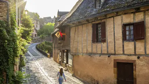 Im Rahmen unserer Gruppenreise spazieren wir durch enge Gassen mit Fachwerkhäusern im mittelalterlichen Dorf Conques.