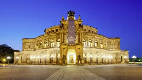 Prachtvolle Fassade der Semperoper in Dresden, bei Dämmerung golden beleuchtet vor einem tiefblauen Abendhimmel, ein Ausblick, welchen wir auch auf unserer Rundreise mit Studiosus genießen werden.