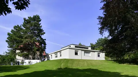 Auf unserer Studienreise besichtigen wir das modernistische Haus am Horn in Weimar, ein Meilenstein der Bauhaus-Architektur auf einem Rasenhügel.