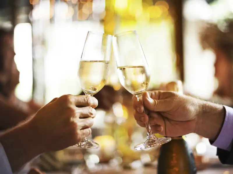 Zwei Gäste einer Eventreise stoßen bei der Silvesterfeier in Heidelberg mit Sektgläsern auf das neue Jahr an.