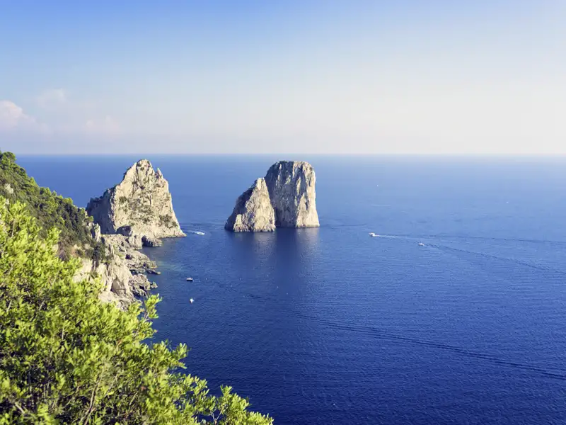 Die Faraglioni-Felsen sind ein Wahrzeichen Capris. Wir besuchen die Stadt am Meer auf unserer Singlereise an den Golf von Neapel.
