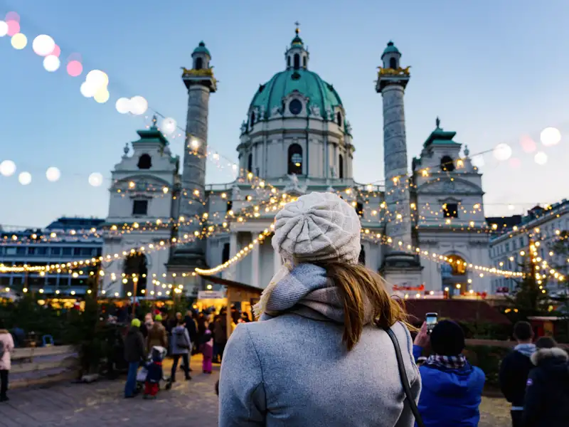 Auf unserer Silvesterreise nach Wien für Singles und Alleinreisende sehen wir auch die Karlskirche. An kälteren Wintertagen ist ein Glaserl Glühwein eine willkommene Gelegenheit, um sich aufzuwärmen.