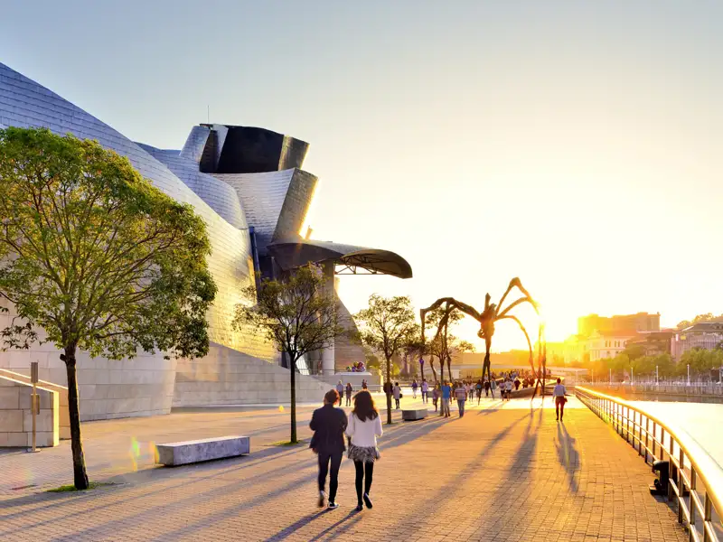 Auf unserer Städtereise CityLights Bilbao erleben Sie in kleiner Gruppe und mit Studiosus-Reiseleitung die Höhepunkte der Stadt, beispielsweise das Guggenheim-Museum mit der Skulptur "Maman" bei Sonnenuntergang.