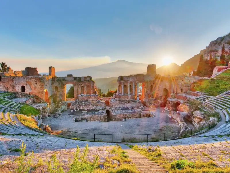 Die antiken Stätten in Taormina, wie das griechische Theater, hier bei Sonnenaufgang, ziehen uns auf unserer Reise für Singles und Alleinreisende nach Sizilien in ihren Bann.
