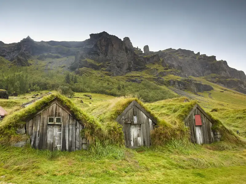 Auf unserer Rundreise für Singles und Alleinreisende durch Island begegnen wir inmitten hügeliger Wiesenlandschaften den traditionellen Grassodenhäusern, die den Isländern über Jahrhunderte Schutz geboten haben.