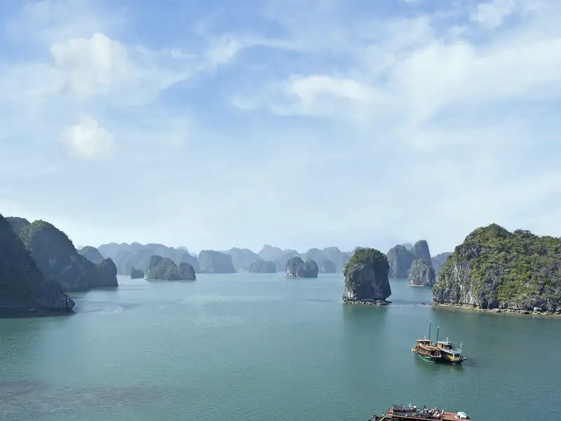 In der Halongbucht in Vietnam bahnt sich unsere Dschunke den Weg durch Karstkegel und Felsnadeln. Wir genießen während unserer Reise für Singles und Alleinreisende entspannte Stunden an Deck.