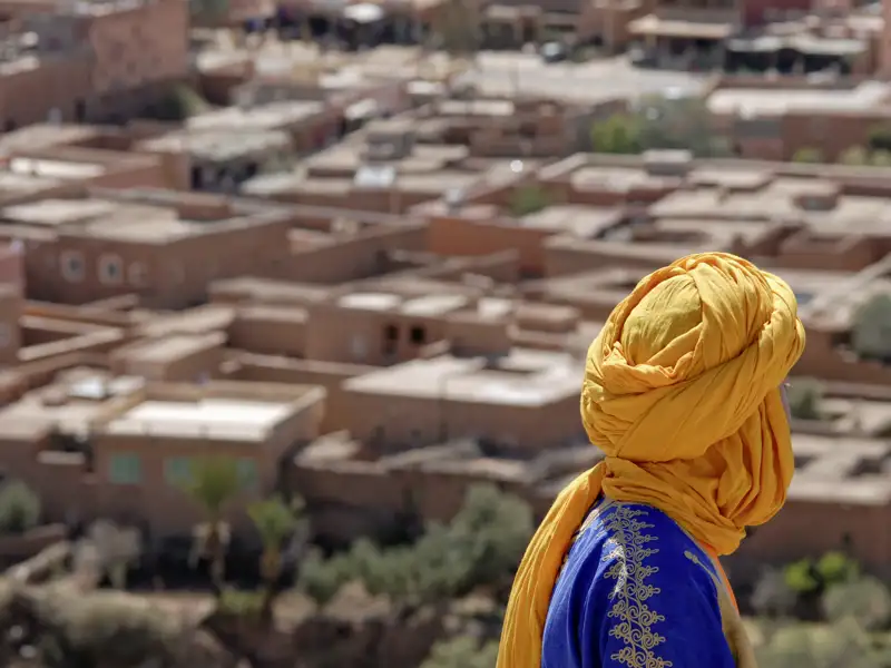 Auf unserer Reise begegnen uns im Süden Marokkos viele typisch gekleidete Einheimische: mit bunten Gewändern und kunstvoll gewickelten Chechs (Turbanen). Und auch wir genießen immer wieder große Ausblicke über die Oasendörfer in den Flusstälern.
