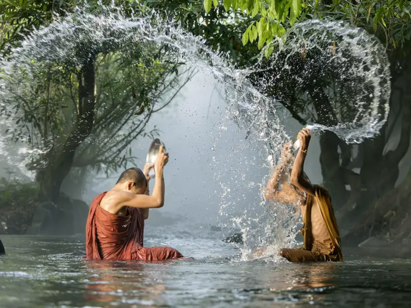 Der Buddhiusmus begegnet uns bei der Rundreise in Thailand immer wieder. Hier waschen sich buddhistische Mönche in einem Fluss.