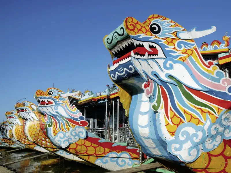 Unweit der Thien-Mu-Pagode in Hue wartet am Parfümfluss unser Drachenboot. Beim Mittagessen mit Märchenstunde an Bord ziehen Dörfer, Reisfelder und Pagoden auf dem Weg zum Kaisergrab von Minh Mang vorbei