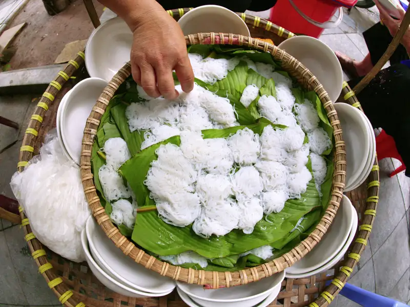 Ab an den Kochtopf! In Tra Que schnippeln, raspeln, rühren und plaudern wir mit Koch Tu, bis die gefüllten Pfannkuchen auf vietnamesische Art auf unseren Tellern duften.