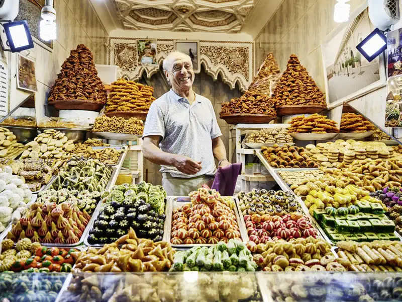 Ein Genuss für die Augen und die Geschmacksnerven sind die vielen bunten und sehr süßen Leckereien, die sich auf jedem traditionell marokkanischen Markt stapeln. Ihre Studiosus-Reiseleitung spendiert auf der 14-tägigen Studienreise Marokko - zwischen Rif und Atlas die ein oder andere Kostprobe.