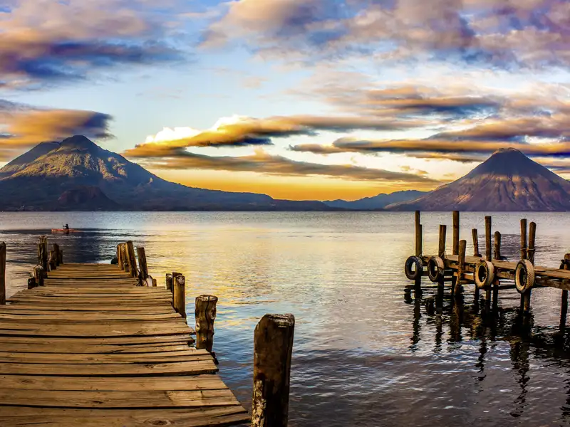 Für viele einer der schönsten Seen der Welt: der Atitlánsee in Guatemala. Auf unserer Studienreise erkunden wir mit Studiosus-Reiseleitung per Boot den tiefblauen See und die Mayasiedlungen an seinem malerischen Ufer.