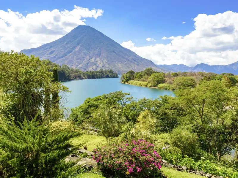 Der Atitlánsee in Guatemala ist von majestätischen Vulkanen umgeben, deren fruchtbare Hänge mit üppiger Vegetation bedeckt sind. Das Naturparadies bietet eine einzigartige Kulisse aus tiefblauem See, grünen Hügeln und imposanten Vulkanen – zu erleben auf der Rundreise mit Studiosus!