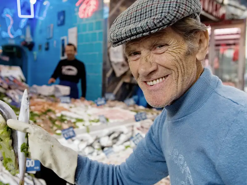 Fischhändler präsentiert frischen Fisch auf dem Markt.