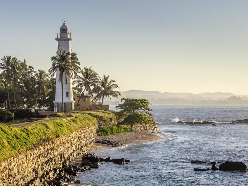 Auf unserer Studienreise durch Sri Lanka besuchen wir auch die alte Kolonialstadt Galle mit ihrem weißen Leuchtturm zwischen Palmen.