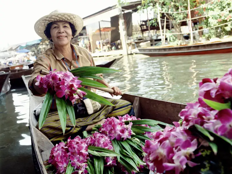 Im Boot geht es dann in den Kanälen der Schwesterstadt Thonburi auf Entdeckungstour: Frauen beim Waschtag, winkende Kinder und Mönche in orangefarbenen Roben, die in Longtail-Booten vorbeiflitzen.