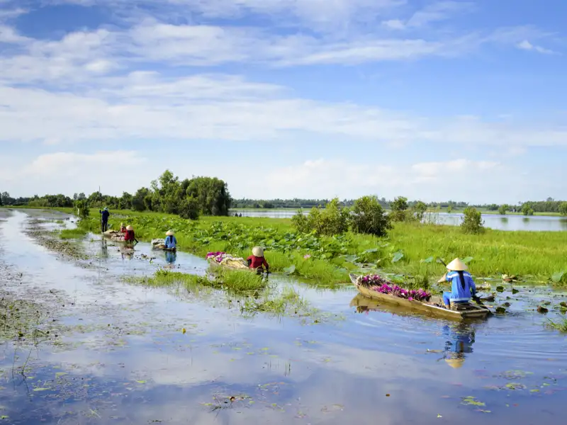 Auf unserer umfassenden Studienreise durch Vietnam und Kambodscha sehen wir im Mekongdelta Bauern, die ihre Waren auf kleinen Holzbooten zum Markt bringen.