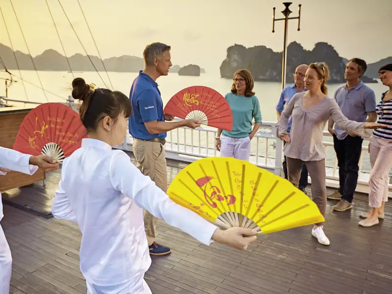 Die Bucht strahlt hell im Morgenlicht. Zeit für Tai-Chi. Die Bootscrew zeigt uns, wie wir unser Yin und Yang an Deck in Schwung bringen.