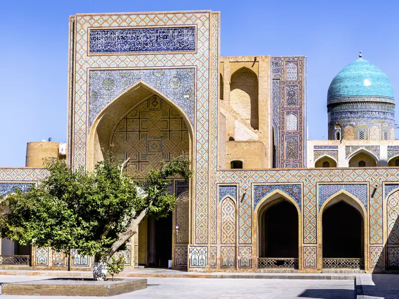 Auf unserer umfassenden Klassik-Studienreise nach Zentralasien - durch Usbekistan, Tadschikistan, Kirgisistan und Kasachstan - besuchen wir auch die Altstadt von Buchara und bestaunen die großen Koranschulen mit ihren typischen blauen Fliesen. Hier das Portal und die Kuppel der Koranschule Ulug Beg.