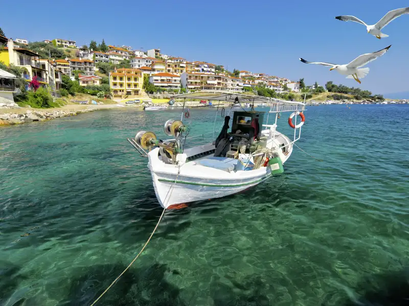 Die Rundreise durch den Norden Griechenland führt unsere Reisegruppe auch nach Chalkidiki, wo immer wieder ein Fischerboot im ruhigen Wasser vor der Küste vor Anker liegt.