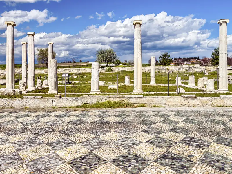 Pella, die einstige Hauptstadt Makedoniens unter Alexander dem Großen, steht bei der Rundreise durch Nordgriechenland mit Studiosus mit auf dem Programm. Zu sehen sind antike Säulen und Mosaiken.