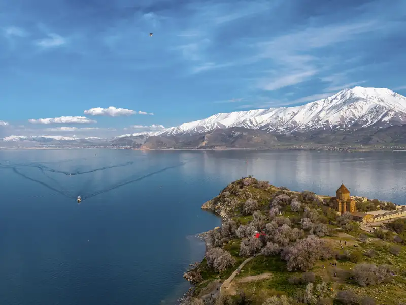 Luftbild der Kirche der Heiligen Apostel auf der Insel Achtamar im Vansee mit schneebedeckten Bergen im Hintergrund. Die Kirche ist eine armenisches Monument aus dem 10. Jahrhundert.